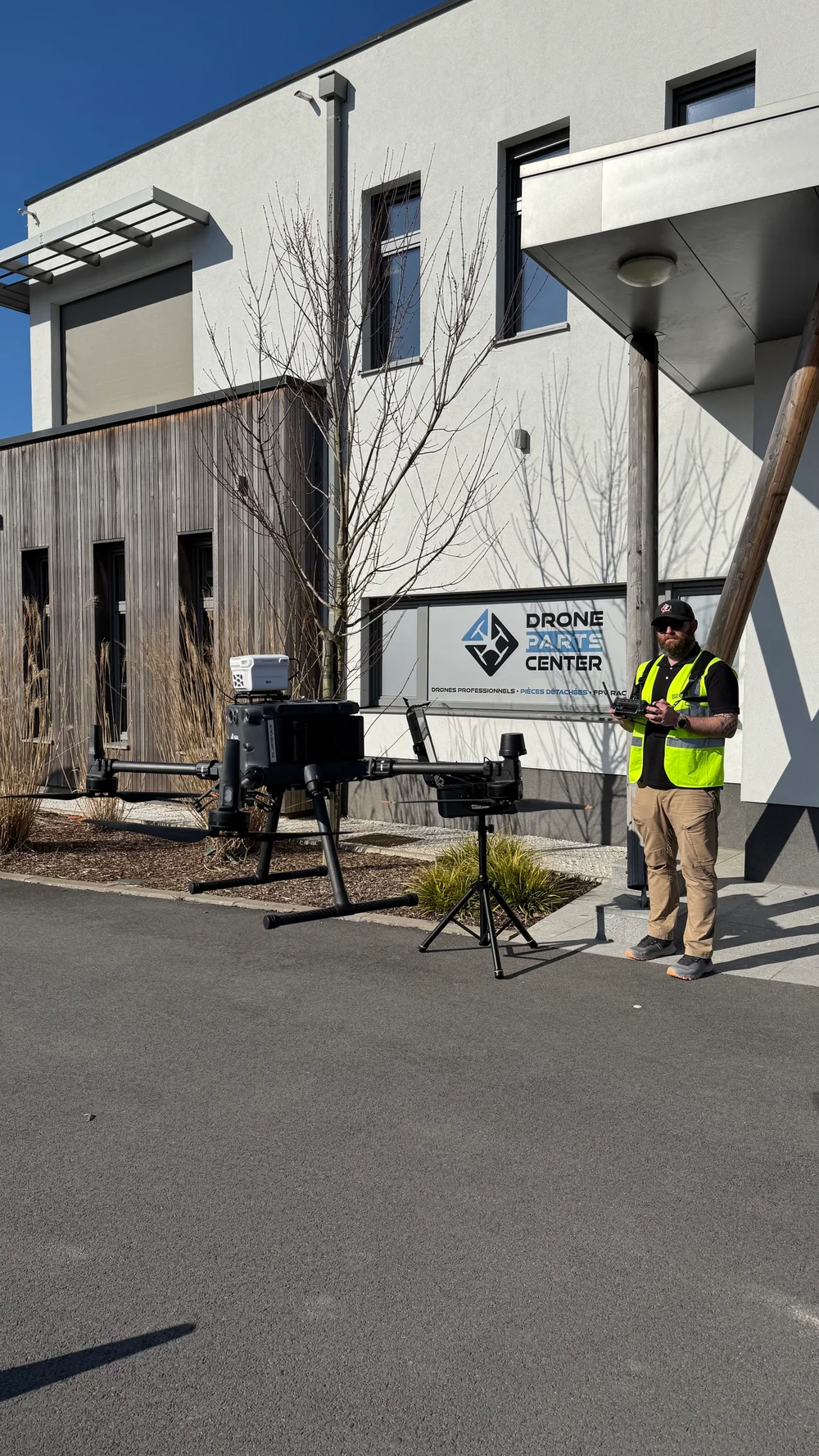 Un opérateur pilote un drone devant les locaux de Drone Parts Center